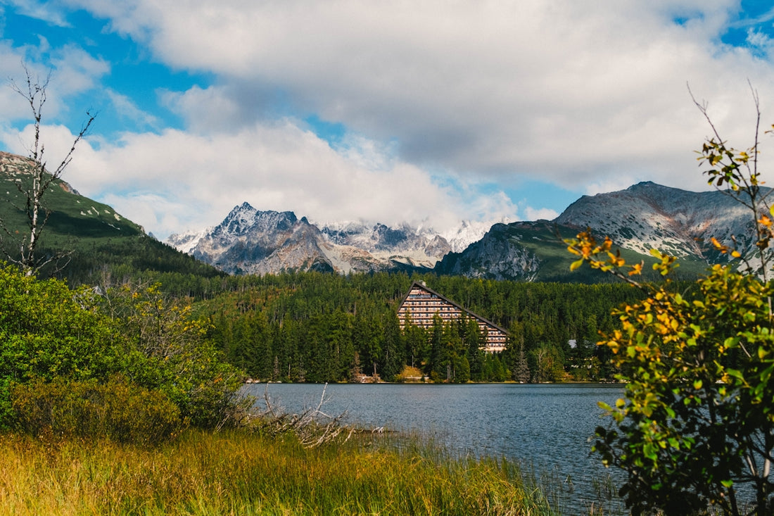 A lake surrounded by mountains under a cloudy blue sky