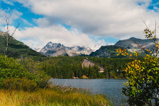 A lake surrounded by mountains under a cloudy blue sky