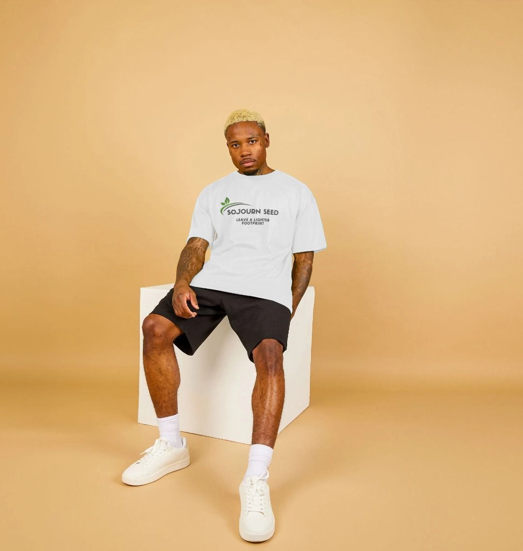 Sojourn Seed white printed organic men's t-shirt worn by model with black shorts and white sneakers