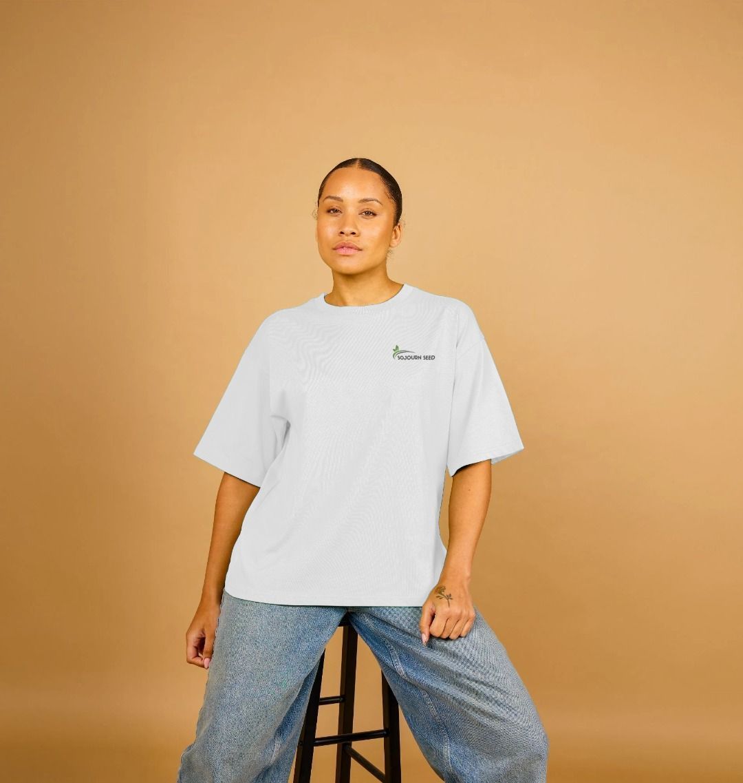 Sojourn Seed printed organic women's t-shirt in white worn with blue jeans on model